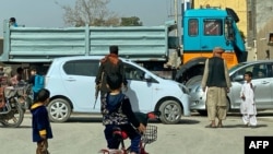 An Afghan security guard checks a vehicle near the site of a suicide bomb attack in Kandahar on March 21, 2024.