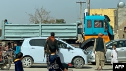 FILE - An Afghan security guard checks a vehicle near the site of a suicide bomb attack in Kandahar, March 21, 2024. A bomb blast on May 20, 2024 has killed at least one person and injured three others in Kandahar. 