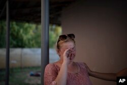 Natalia Rosolova cries outside her home in Kupiansk-Vuzlovyi, Ukraine, Aug. 23, 2023.