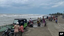 Warga berdiri di tepi laut sebelum Topan Mocha menerjang, di Sittwe, Negara Bagian Rakhine, Sabtu, 13 Mei 2023. (Foto: AP)