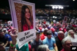 FILE - A campaign-goer holds up a poster with a photo of Laken Riley before then-presidential candidate Donald Trump speaks at a rally in Rome, Georgia, March 9, 2024. Riley was a Georgia nursing student who was murdered last year by a Venezuelan man.