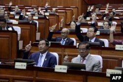 Perdana Menteri Kamboja Hun Sen (kiri depan) dan anggota parlemen lainnya memberikan suara selama pertemuan parlemen di gedung Majelis Nasional di Phnom Penh. (Foto: AFP)