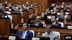 FILE - Cambodia's Prime Minister Hun Sen (front L) and other lawmakers voting during the parliament meeting at the National Assembly building in Phnom Penh. (Photo by Handout / CAMBODIA NATIONAL ASSEMBLY / AFP)