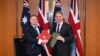 Secretary of State for Defense of the United Kingdom Grant Shapps (L) and Australian Defense Minister Richard Marles exchange Defense Treaty documents during a meeting at Parliament House in Canberra, March 21, 2024. (AAP Image/Lukas Coch via Reuters)
