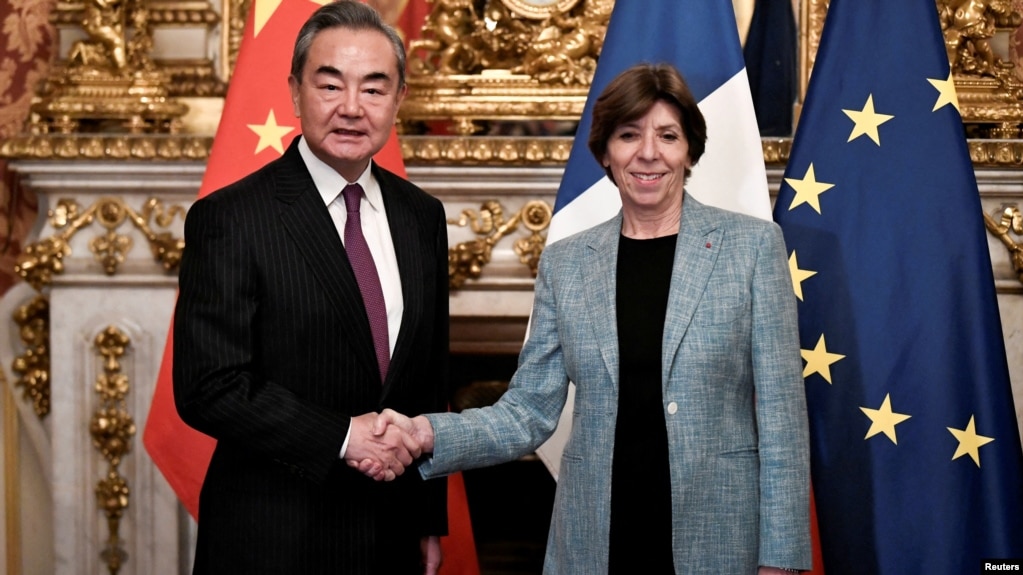 2023年2月15日中共中央外事办公室主任王毅在法国巴黎出席会议时与法国外交和欧洲事务部长凯瑟琳·科隆纳握手(photo:VOA)