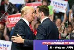 Mantan Presiden AS dan calon presiden tahun 2024 Donald Trump (kiri) menyapa Senator dan calon wakil presiden AS J.D. Vance saat mereka menghadiri kampanye pertama mereka bersama di Van Andel Arena di Grand Rapids, Michigan, 20 Juli 2024. (Foto: AFP)