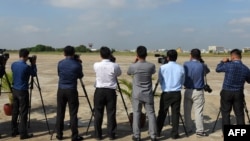 FILE - Cambodian journalists take pictures at a military airbase in Phnom Penh, Nov. 20, 2018. USAID announced in July a $7 million grant to bolster independent media in the country.