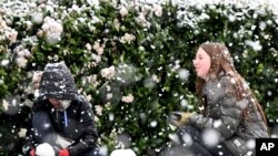 Brody Mielke, left, 10, and his older sister Braelynn, 12, make a snowman as snow falls at approximately the 1,700 foot level in front of their Fontana, Calif., home in Hunters Ridge, Feb. 25, 2023. (Will Lester/The Orange County Register via AP)