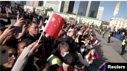 In this image taken from video, Chinese nationals wave Chinese flags at the welcome ceremony for Pope Francis in Ulaanbaatar, Mongolia, on Sept. 2, 2023.