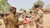 Head of Burkina Faso's army Colonel Adam Nere receives a flag from French Lieutenant-Colonel Louis Lecacheur during a military handover ceremony at the base of Kamboincin, Burkina Faso, Feb. 18, 2023. (Burkina Faso's General Staff of the Armed Forces via Reuters)