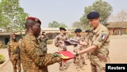 Head of Burkina Faso's army Colonel Adam Nere receives a flag from French Lieutenant-Colonel Louis Lecacheur during a military handover ceremony at the base of Kamboincin, Burkina Faso, Feb. 18, 2023. (Burkina Faso's General Staff of the Armed Forces)