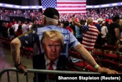 Seorang pendukung yang mengenakan kaos bergambar mantan Presiden AS dan calon presiden dari Partai Republik Donald Trump pada acara kampanye Trump di Philadelphia, Pennsylvania, AS, 22 Juni 2024. (Foto: REUTERS/Shannon Stapleton)