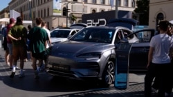 Sejumlah pengunjung memperhatikan mobil listrik buatan produsen China BYD di sebuah pameran motor di Munich, Jerman, 3 September 2023. (Foto: Matthias Schrader/AP Photo)