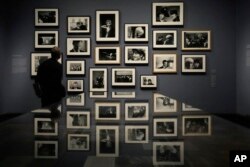 Seorang pengunjung melihat foto-foto di pameran Paul McCartney Photographs 1963-64: Eyes of the Storm di Inggris (dok: AP)