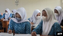 Sejumlah siswi sekolah menengah kejuruan di Cipatat, Bandung, Jawa Barat mengenakan hijab di kelas, 24 Agustus 2023. (Foto: Timur Matahari/AFP) 