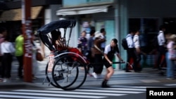 Rickshaw puller Akina Suzuki, 19, drives a rickshaw around Asakusa district in Tokyo, Japan, June 18, 2023.