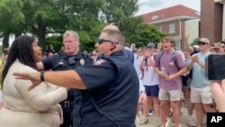 In this photo taken from video provided by Stacey J. Spiehler, a pro-Palestinian protester is confronted by hecklers at the University of Mississippi, May 2, 2024, in Oxford, Miss. The hecklers vastly outnumbered pro-Palestinian demonstrators.