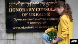 Một phụ nữ đặt hoa trước Tòa Lãnh sự Ukraine tại Denpasar trên đảo Bali của Indonesia ngày 24/2/2023 nhân kỷ niệm một năm ngày Nga xâm lược Nga.