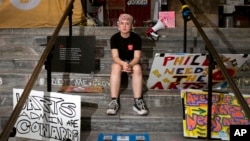 Cyrus Nasib, 18, sits on the steps of the University of the Arts, on June 14, 2024, in Philadelphia. Students at the university got the sudden news that their school would be shutting down within days. (AP Photo/Joe Lamberti)