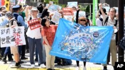 A protester holds a sign during a rally against the treated radioactive water release from the damaged Fukushima nuclear power plant, in front of Tokyo Electric Power Company Holdings (TEPCO) headquarters, Aug. 24, 2023, in Tokyo. 
