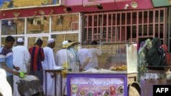 FILE - People queue for bread outside a bakery amidst a food crisis in the south of Khartoum on April 17, 2023. 