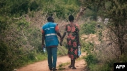 Mfuasi aliyeokolewa kutoka msituni akisaidiwa na mfanyakazi wa kujitolea, jirani na msitu wa Shakahola huko Malindi terehe 25, Aprili 2023. Picha na Yasuyoshi CHIBA / AFP. 