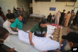 Palestinians carry the bodies of the Awaja family killed in the Israeli bombardment of the Gaza Strip in Rafahn on Friday, Oct. 20, 2023.