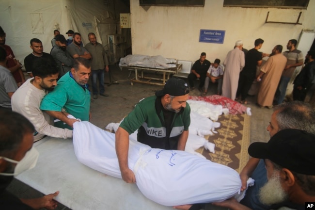 Người Palestine khiêng thi thể của gia đình Awaja thiệt mạng trong vụ bắn phá của Israel vào Dải Gaza ở Rafahn vào thứ Sáu, ngày 20 tháng 10 năm 2023.