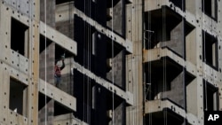 FILE - A worker uses a drill during the construction of a new apartment building in Beijing, China, October 26, 2021.