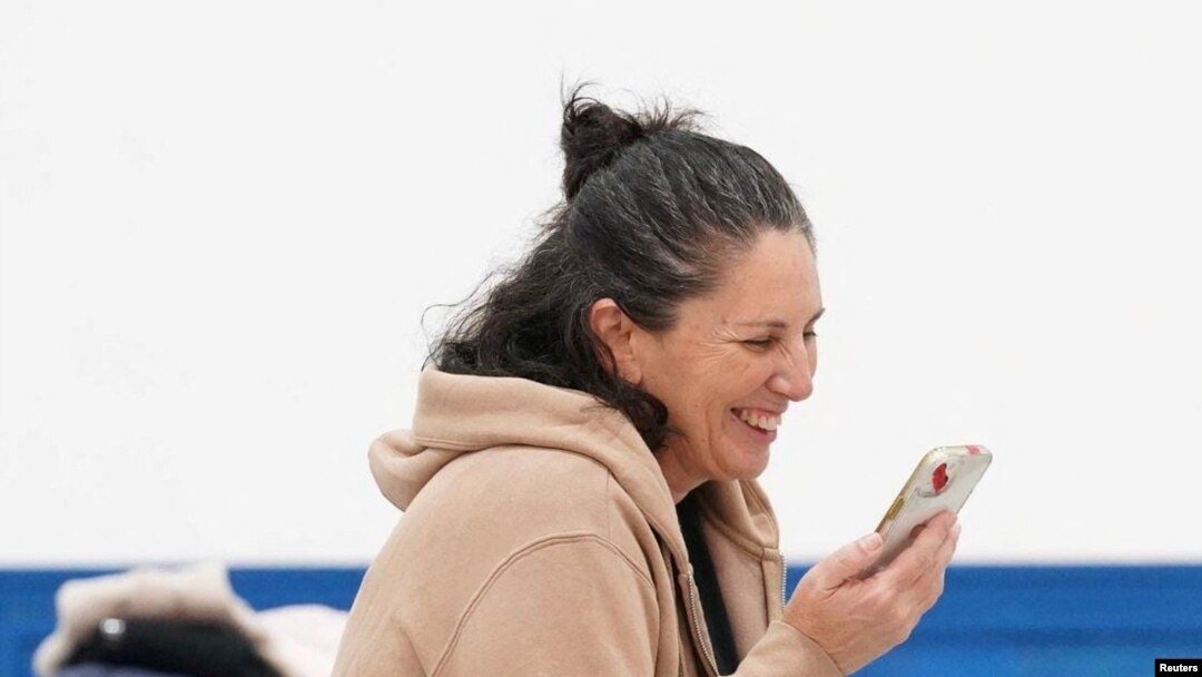 FILE - Liat Beinin, 49, speaks with family, Nov. 29, 2023, having just been freed from Hamas captivity. Two Palestinian American families' lawsuit says the U.S. has not done as much to evacuate their U.S. relatives as it did for Israeli dual nationals.