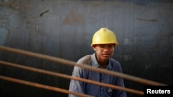 FILE - A construction worker at the port project in Sittwe, Myanmar, May 19, 2012, located in northwest Myanmar, where the Kaladan River flows out into the Bay of Bengal.