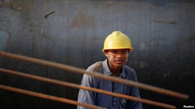 FILE - A construction worker at the port project in Sittwe, Myanmar, May 19, 2012, located in northwest Myanmar, where the Kaladan River flows out into the Bay of Bengal.