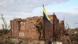 An assault unit commander from the 3rd Assault Brigade raises the Ukrainian flag as a symbol of liberation of the frontline village of Andriivka, Donetsk region, Ukraine, Sept. 16, 2023