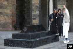 Taliban fighters take selfies by the tomb of Afghan Kind Nadir Shah in Kabul, Afghanistan, Wednesday, April 24, 2024. (AP Photo/Siddiqullah Alizai)