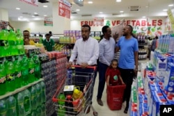 Ahmed Khadar Abdi Jama (kiri), berbelanja di sebuah supermarket di Mogadishu, Somalia, 25 Maret 2023. (AP/Farah Abdi Warsameh).