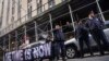 Demonstrators unveil a banner outside Manhattan's district attorney office, supporting a grand jury vote to indict former President Donald Trump, March 30, 2023, in New York. 