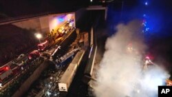 Smoke rises from trains as firefighters and rescuers operate after a collision near Larissa city, Greece, early March 1, 2023. 