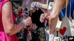 Para penggemar Taylor Swift bertukar gelang di pusat Kota Wina, Austria, 8 Agustus 2024. (Foto: Heinz-Peter Bader/AP Photo)