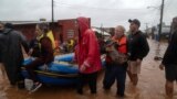 Residents and a dog are evacuated from a flooded area of Sao Sebastiao do Cai, Rio Grande do Sul State, Brazil, on May 2, 2024. 