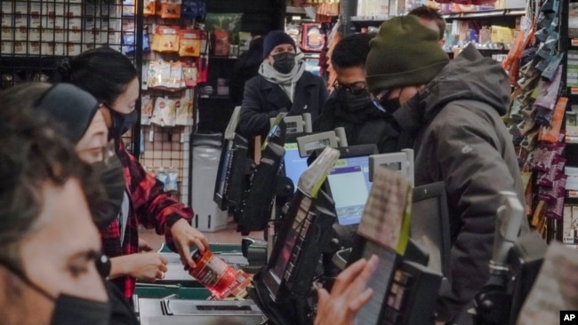 Store clerks and shoppers wear masks at Brooklyn's Park Slope Co-Op grocery store, Dec. 7, 2023, in New York.