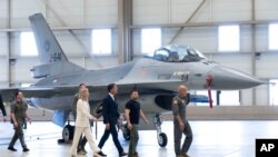 ယူကရိန်းသမ္မတ Volodymyr Zelenskyy (ယာဘက်ဒုတိယ) နဲ့ နယ်သာလန်ဝန်ကြီးချုပ် Mark Rutte (ဗဟို) တို့ F16 ဂျက်တိုက်လေယာဥ်တွေကို ကြည့်ရှုနေစဥ်။ (သြဂုတ် ၂၀။ ၂၀၂၃) 