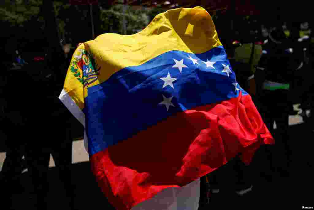 Un manifestante sostiene una bandera venezolana, mientras trabajadores sindicales, miembros de partidos políticos de oposición y otros participan en una protesta contra el gobierno del presidente de Venezuela, Nicolás Maduro, durante el Primero de Mayo, en Caracas.