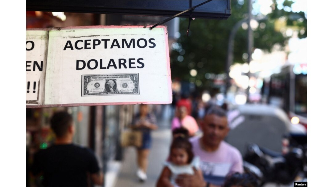 Sebuah tanda di luar toko bertuliskan dalam bahasa Spanyol "Kami menerima Dolar" di Buenos Aires, Argentina, 12 Desember 2023. (REUTERS/Tomas Cuesta)