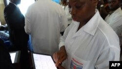 FILE - An Ivorian doctor uses a tablet computer at Bouake hospital's telemedicine department, in Bouake, Ivory Coast, June 20, 2019.