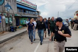 Florida Governor Ron DeSantis, accompanied by his wife Casey, walks around an affected area in the aftermath of Hurricane Idalia, in Cedar Key, Florida, Aug. 31, 2023.
