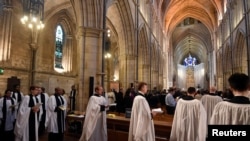FILE - Members of the clergy process in for the Choral Evensong service at Southwark Cathedral in London, March 15, 2020.
