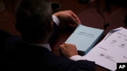 资料照片: 2024年3月19日一名议员在香港立法会在二期间阅读《维护国家安全法案》副本