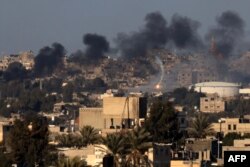 This photo taken Jan. 15, 2024, from Rafah shows a flare and smoke billowing over Khan Younis in the southern Gaza Strip during Israeli bombardment, amid battles between Israel and the Palestinian militant group Hamas.