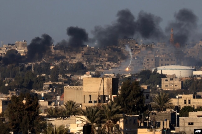 This photo taken Jan. 15, 2024, from Rafah shows a flare and smoke billowing over Khan Younis in the southern Gaza Strip during Israeli bombardment, amid battles between Israel and the Palestinian militant group Hamas.