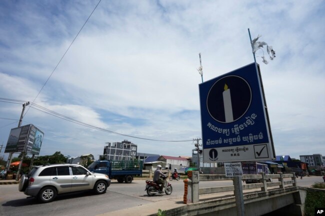 រូបឯកសារ៖ ស្លាកគណបក្សភ្លើងទៀនត្រូវបានដាក់នៅជាប់ស្ពានមួយតាមដងវិថីនាជាយក្រុងភ្នំពេញ កាលពីថ្ងៃទី ២៥ ខែឧសភា ឆ្នាំ ២០២៣។